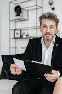 Mature businessman sitting and reviewing documents in a modern office setting.